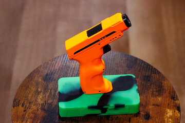 An orange hand torch on a green block of silicone