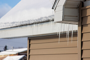 Icicles on a snow-covered house in winter
