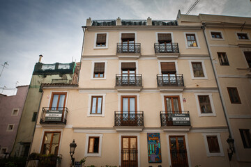 Fototapeta premium The renovated facade of a residential building with balconies in Ciutat Vella, the historic old town of Valencia, Spain, illustrating urban housing and local real estate.