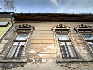 Decaying building facade in Subotica showing cracked plaster and signs of deterioration on old windows. The image highlights aging urban architecture and real estate conditions.