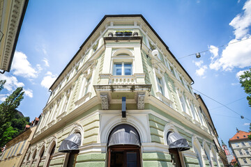 The ornate green facade of a historic residential building on a corner in the old town center of Ljubljana, Slovenia, a symbol of property and real estate in the slovenian capital city.