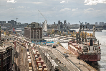 Industrial port of Montreal with container trains, cargo ship, logistics infrastructure,...