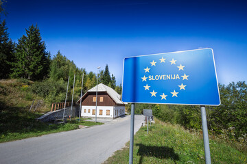 A large blue road sign with the European Union stars welcoming drivers to Slovenia at a border crossing with Austria. Austria and Slovenia are part of the Schengen area and the EU.