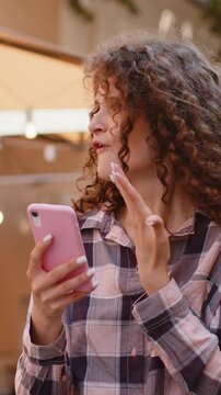Oh my God Wow. Excited happy joyful winner pretty young woman use smartphone typing browsing celebrating win good message news. Lady with mobile phone walking in urban city sunshine street outdoors