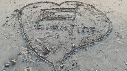 Heartfelt sand drawing on beach showcasing Palestine flag and message of love for nation and...