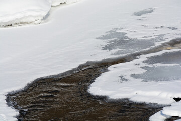 氷が溶け始めた冬の川
