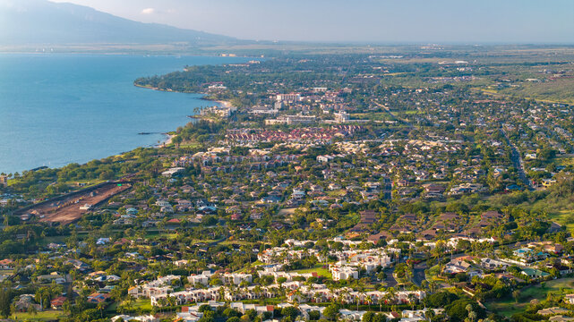Panoramic aerial view of Wailea and Kihei towns showcaing resorts and vacation homes in Maui, Hawaii landscape along the coast with mountains in the background