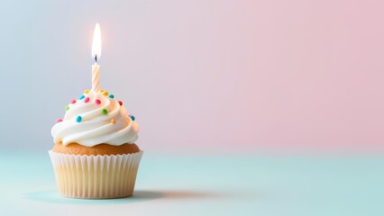 A single cupcake with white frosting and colorful sprinkles sits on a pastel background with a lit candle