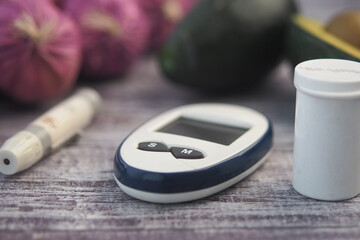Diabetes tools placed on a wooden surface with fruits