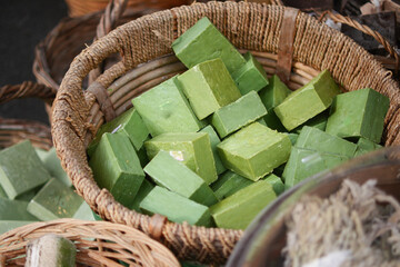 Green soap blocks in a woven basket at a market