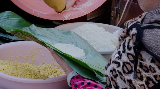 An aunt is wrapping zongzi, a traditional food for the Chinese Dragon Boat Festival.