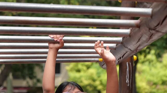 Child plays on monkey bars at a local park