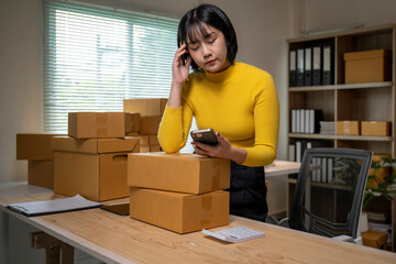 Stressed asian businesswoman having problem with delivery of her online business