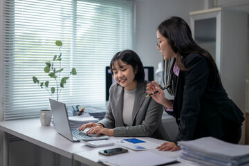Businesswomen working together using laptop in office