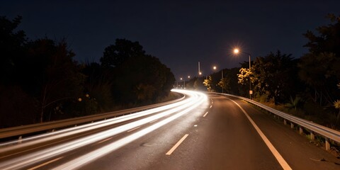 Obraz premium Cars stream along an illuminated highway at night