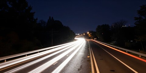 Streaks of light from vehicles streak along a highway at night during long exposure