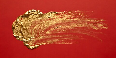 Swirling golden paint glistens against a vibrant red backdrop