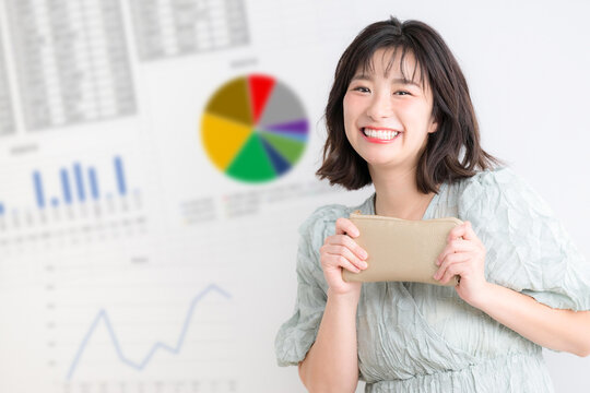 NISAやiDeCoで積み立て投資を考える女性、家計管理と資産運用を示す投資グラフ背景　カメラ目線笑顔