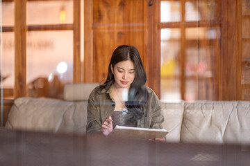 Asian woman writing notes in a cafe