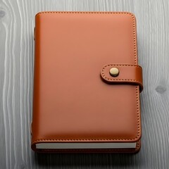 A brown leather notebook closed on wood