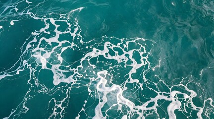 Aerial view of ocean water surface with white foam pattern creating interesting design