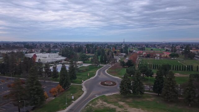 Drone perspectives show the California State Stanislaus University campus as evening settles in, with overcast skies, subdued colors, and campus structures framed by gentle twilight.