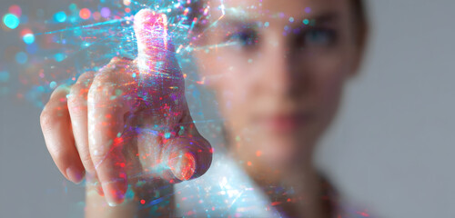 Close-up of a woman's finger touching a glowing, colorful digital interface, representing futuristic technology and innovation.
