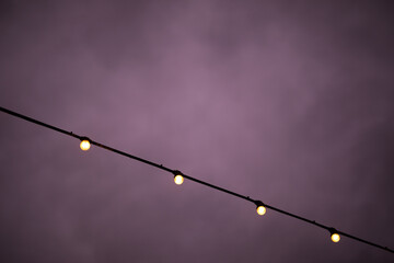 Evening string lights illuminate dark sky