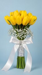 Beautiful bouquet of bright yellow tulips with white ribbon