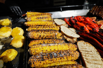 Grilled corn, polenta and paprika on an outside charcoal metal grill.