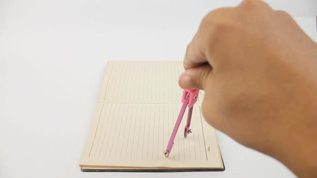 hand holding compass school drawing on book