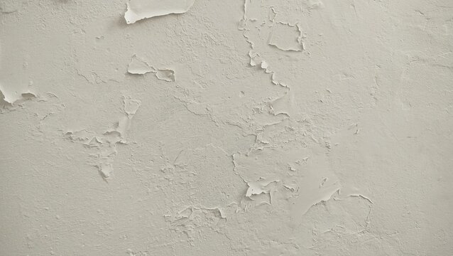 The surface or background of an old white wall with peeling paint. photo of a damp and moldy house wall. Paint used for painting non-standard house walls causes the wall paint to peel off.