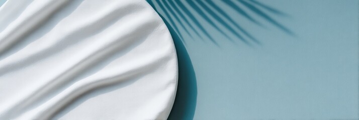 青い背景の上に置かれた白いプレートと葉