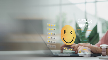 Customer leaving a 5-star review on digital interface with smiley face icon, representing customer...