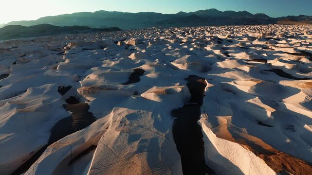 Close aerial of cracked pumice formations abstract patterns across volcanic desert terrain