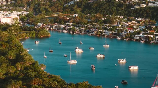 Aerial of marina boats anchored in turquoise river mouth near coastal town, Noosa Queensland Australia at golden hour sunset