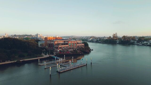 High drone overlooking Brisbane River bend with suburbs extending along both banks, Brisbane City Council Powerhouse along water