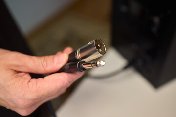 Setting up audio connection professionally, Attaching sound cable to subwoofer in studio, Closeup of hands securing audio cable into subwoofer in recording studio setting © Евгений Вершинин
