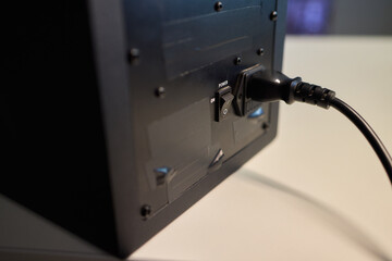 Checking subwoofer connection details, Close view of fingertip near cable connection, Detailed inspection of subwoofer power port with ambient lighting and focus on fingertip © Евгений Вершинин