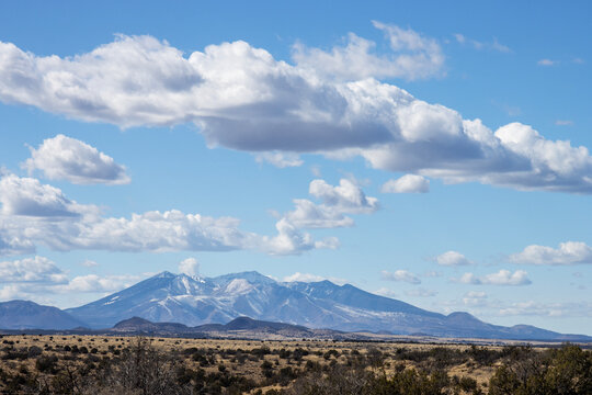 Snow-capped San Francisco Peaks under spectacular clouds near Flagstaff, Arizona, as seen from across the prairie near I-40