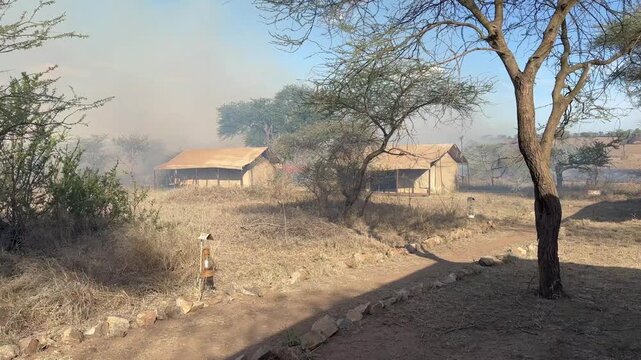 Wildfire has come dangerously close to a tented camp in Serengeti National Park. Tanzania.