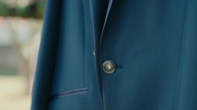 Close up of blue suit jacket showing button and fabric texture