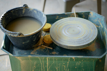 pottery wheel with clay and tools on work surface, showcasing art of ceramics. scene captures creative process of shaping clay into beautiful forms