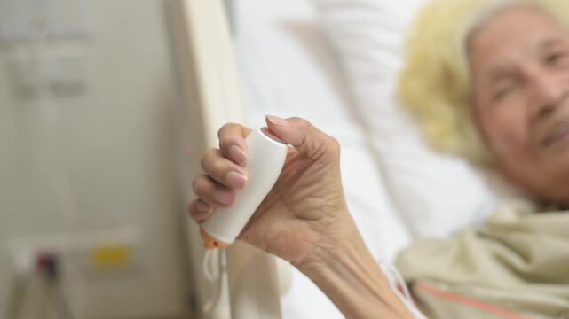 Elderly patient pressing nurse call button