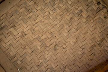 Woven bamboo mat with intricate patterns, showcasing natural textures and earthy tones. This traditional craft highlights beauty of handmade materials