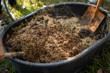 Composting mixture in wheelbarrow, rich in organic materials, ready for gardening. This blend promotes healthy soil and plant growth