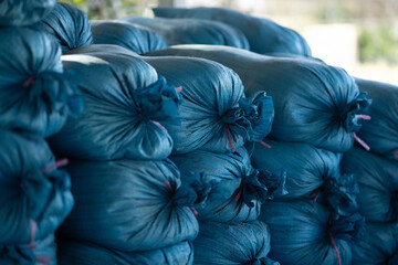 Bags of blue fabric stacked neatly, showcasing their texture and color. arrangement creates visually appealing pattern, ideal for various uses in storage or decoration