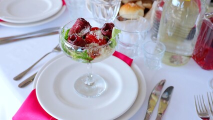 Thin beef carpaccio rolled delicately, garnished with crisp lettuce, ripe tomatoes, and shaved...