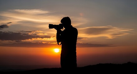 Silhouette of a person holding a camera against a brilliant sunset sky