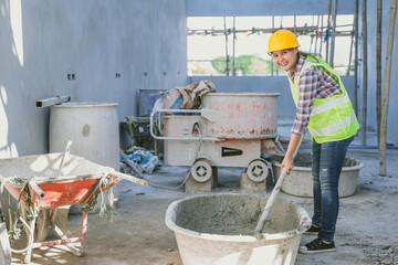 Happy smile woman worker work in construction site doing mix concrete for happy home building labor
